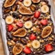 No-bake collagen chocolate bark topped with dried figs, dates, strawberries, banana slices, pistachios and coconut