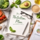 Flat lay of healthy foods, nutrition notebook, measuring tape and meal planning tools on a light surface.